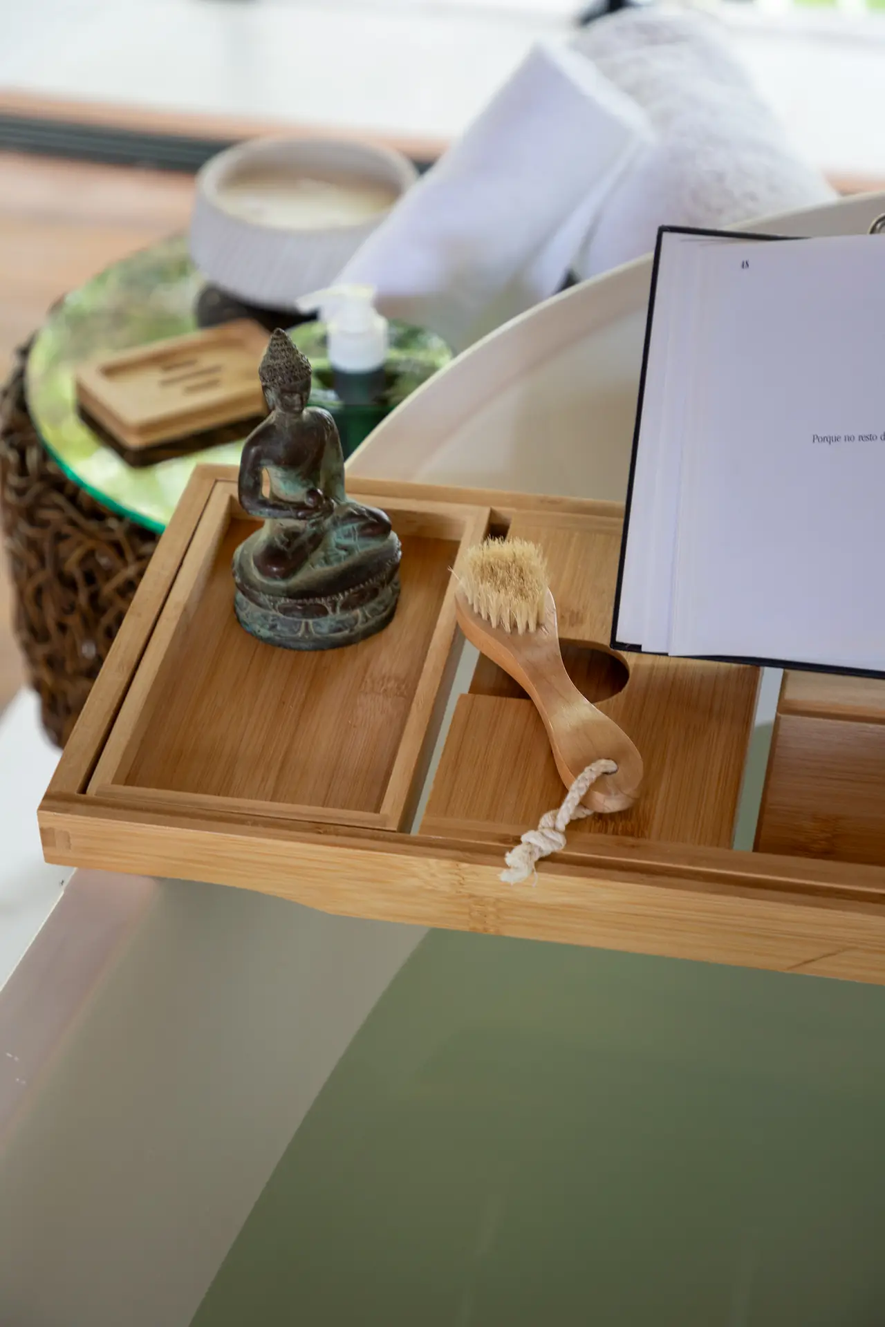 Bandeja de bambu com estátua de Buda, escova e livro, com o fundo desfocado